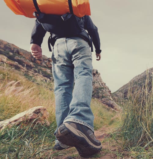 man hiking up a hill